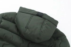 Dettaglio della giacca invernale verde scuro con cappuccio, tessuto opaco e imbottitura