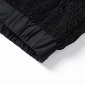 Detail der schwarzen Teddyfleece-Jacke mit elastischen Bündchen und Materialmix-Textur