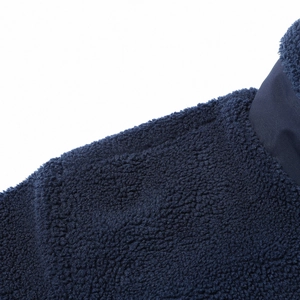 Detail der dunkelblauen Teddy-Fleece-Textur mit glattem Besatz an Schulter und Kragen