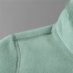 Macro shot of mint green fleece jacket showing premium stitching and soft texture detail