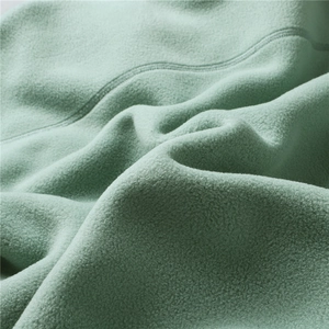 Detailed close-up of soft light green polar fleece fabric texture and stitching detail
