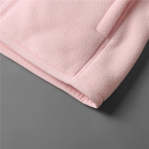 Macro shot of pink polar fleece fabric detail showing neat stitching and pocket hem
