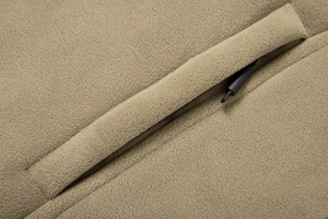 Dettaglio della giacca tattica in pile che mostra una tasca con zip e texture spessa