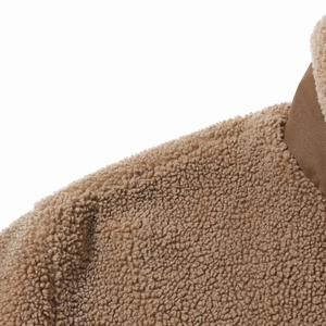 Detailansicht des Kragens einer Teddy-Fleecejacke in Camel mit dunkler Stoffapplikation