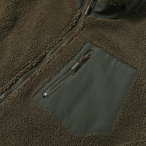 Detailansicht der olivgrünen Teddy-Fleecejacke mit Nylontasche und robustem Metallreißverschluss