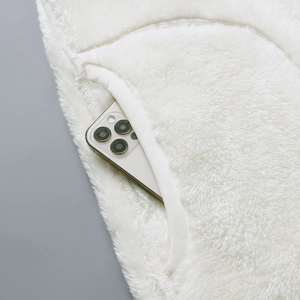 Detail view of deep side pocket on white fleece jacket with smartphone for scale