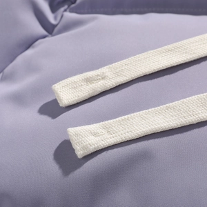 Detail shot of purple puffer jacket fabric with premium white braided drawstrings