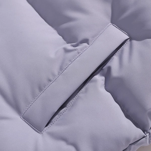 Detail of light purple quilted jacket showing precise stitching and windproof pocket design