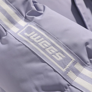 Detailed macro view of the purple quilted jacket featuring a JUCCES woven logo tape