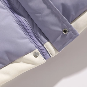 Detail of purple padded jacket showing zipper closure and metallic snap button texture