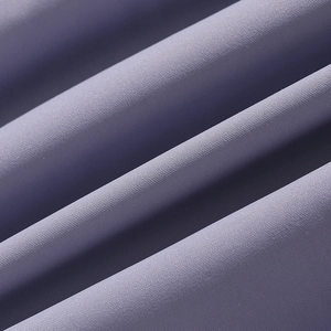 Macro shot of dark purple padded coat fabric showing fine plain weave texture