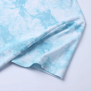 Détail de la manche en coton tie-dye et des coutures doubles à l'ourlet du t-shirt