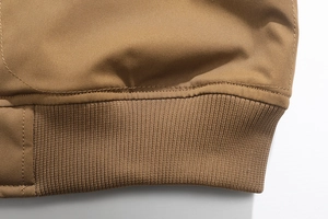 Dettaglio dell'orlo della giacca kaki con maglia elastica a coste e cuciture rifinite