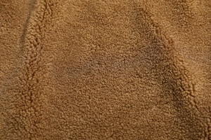 Dettaglio ravvicinato della fodera in pile sherpa marrone con texture morbida e calda