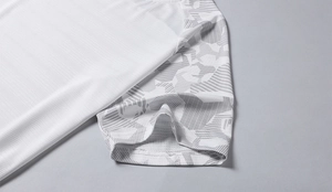 Detail von weißem atmungsaktivem Funktionsstoff mit grauem Camouflage-Druck am Ärmel