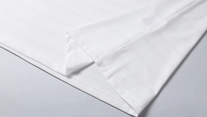 Nahaufnahme von weißem Mesh-Gewebe mit Seitenschlitz und feinen Nähten am T-Shirt