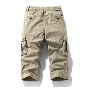 Detail view of khaki cargo shorts showing elastic waist and back pockets on white background