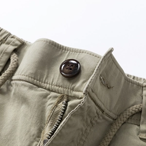 Detail of cargo pants waist with wooden button, zipper fly and drawstring closure