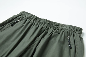 Dettaglio dei pantaloncini cargo verde militare con vita elastica e tasche a zip