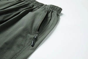 Dettaglio pantaloncini verde militare con elastico in vita e tasca con zip di qualità
