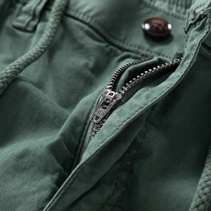 Detailed close-up of durable metal zipper and waist drawstring on cargo pants