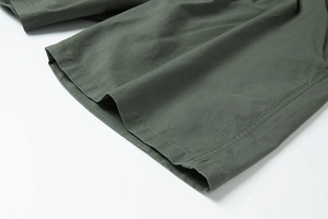 Dettaglio ravvicinato dei pantaloncini in cotone verde militare con doppia cucitura