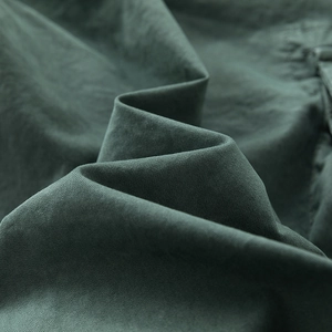 Detailed macro view showing the thick dark green twill fabric texture of cargo pants