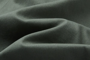 Vista macro dettagliata della trama del tessuto twill oliva scuro per pantaloncini in cotone