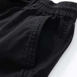 Close-up of elastic waistband and pocket stitching on black cargo pants