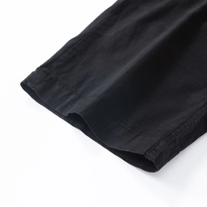 Detail of the high-quality single needle hem stitching on black cotton cargo pants