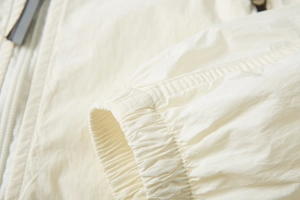 Detail of ivory white ice silk sun protection fabric with elastic cuff and smooth zipper