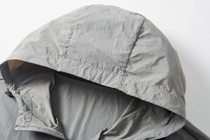 Macro detail of UPF100+ sun protection hoodie showing grey technical fabric and zipper