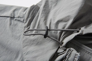 Close-up of adjustable elastic drawstring and metal eyelets on sun protection jacket
