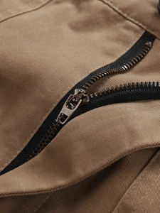 Close-up of bronze metal zipper and high-quality khaki cotton twill fabric on cargo pants