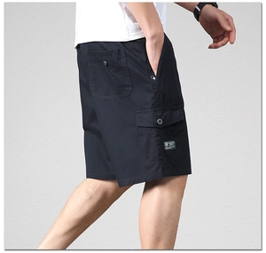 Detailed close-up of navy cargo shorts featuring cotton fabric and side flap pockets