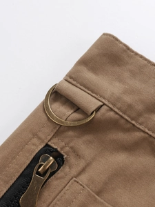 Detail of khaki cargo pants featuring durable twill fabric and bronze D-ring with zipper