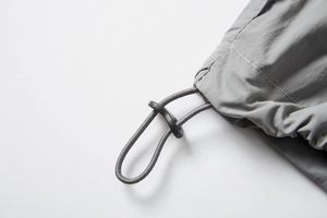 Detail of adjustable drawstring with plastic slider on gray UPF100+ sun protection jacket