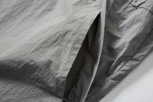 Detail view of grey sun-protective fabric featuring reinforced side pocket stitching