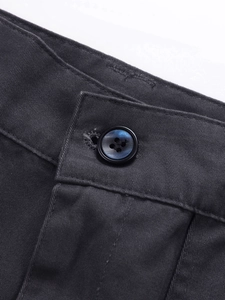 Detailed close-up of heavy-duty cotton twill waistband with a blue polarized button