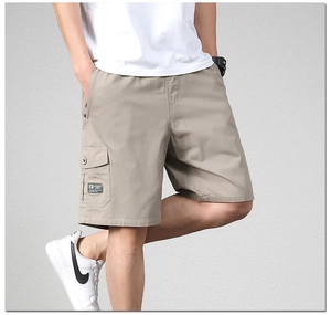 Detail of khaki cotton cargo shorts featuring a large side pocket and elastic waistband