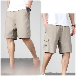 Detail of khaki cotton cargo shorts featuring elastic waist and large side flap pockets