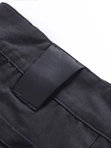 Detail of waist leather patch and heavy-duty twill fabric on men cargo pants