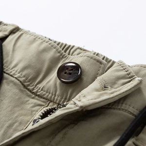 Detailed macro view of khaki cotton twill pants waist with resin button and metal zipper