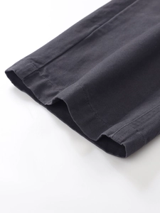 Detailed close-up of dark grey cargo pants leg opening with neat stitching and cotton twill