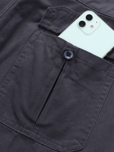 Close-up of deep cargo pocket on gray cotton pants showing large capacity with a smartphone