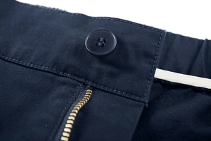 Dettaglio pantaloncini cargo blu navy con bottone in resina e vita elastica sul retro