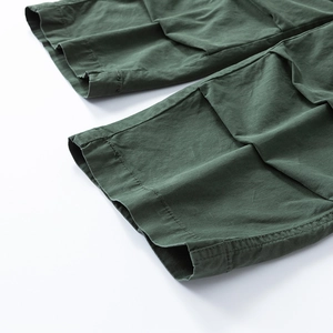 Detailed close-up of dark green cargo pants cuffs with double-needle stitching quality