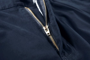 Dettaglio ravvicinato della cerniera metallica e del tessuto twill dei pantaloncini cargo