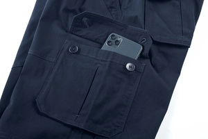 Dettaglio della tasca laterale dei pantaloncini cargo con patta a due bottoni e telefono