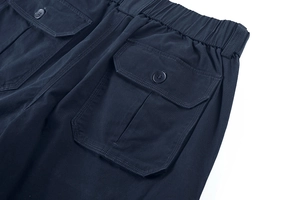 Dettaglio dei pantaloncini cargo blu navy con elastico in vita e tasca a patta con bottone